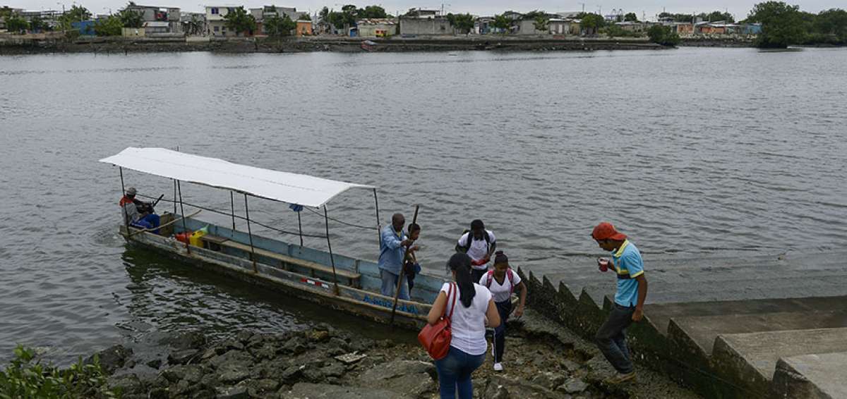Los alumnos cruzan el estero Salado para acudir a los centros educativos en la Isla Trinitaria o suburbio.