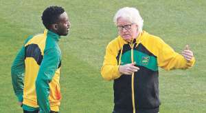 Winfried Schafer (d), director t&eacute;cnico de la selecci&oacute;n de f&uacute;tbol de Jamaica, conversa con uno de sus jugadores durante el entrenamiento del viernes pasado. Foto: AFP