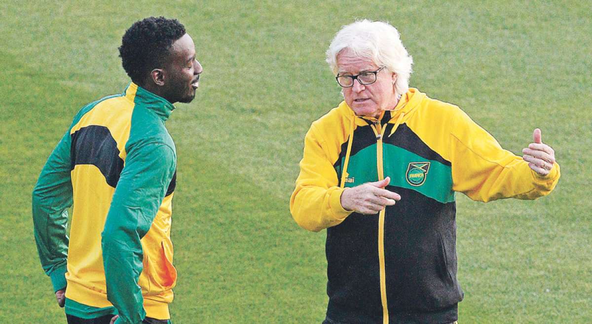 Winfried Schafer (d), director t&eacute;cnico de la selecci&oacute;n de f&uacute;tbol de Jamaica, conversa con uno de sus jugadores durante el entrenamiento del viernes pasado. Foto: AFP
