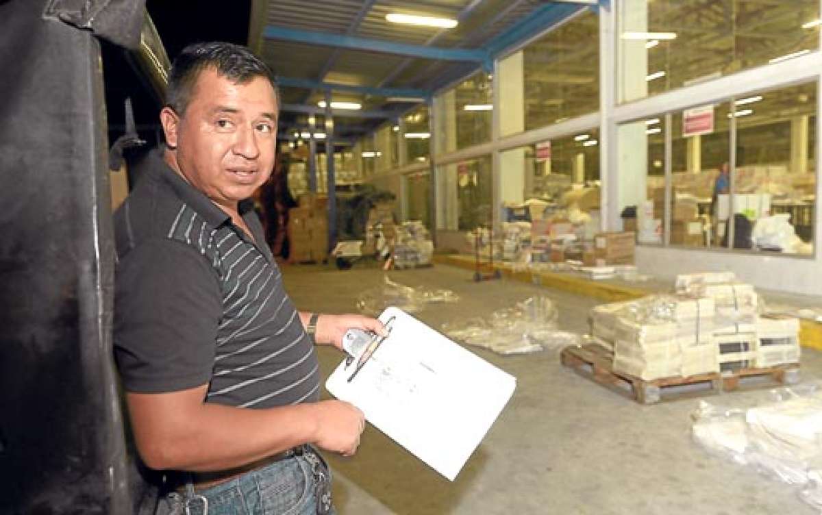 Antes de las 19:00, William Godoy ya est&aacute; en la planta de Editogran, en la av. Carlos Julio Arosemena de Guayaquil, a la espera de que le despachen los ejemplares que lleva hasta Azuay. Fotos: Pilar Vera |  El Tel&eacute;grafo