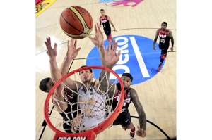 El ucraniano Slava Kravtsov (centro) encesta a pesar del intento de bloqueo de los norteamericanos Klay Thompson (izq.) y DeMarcus Cousins. Foto: AFP.