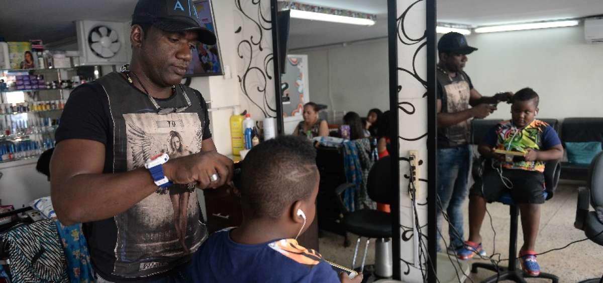 En su local de la 25 y la Ch, en el Suburbio Oeste, atiende a sus clientes. Corta el cabello a hombres y mujeres.