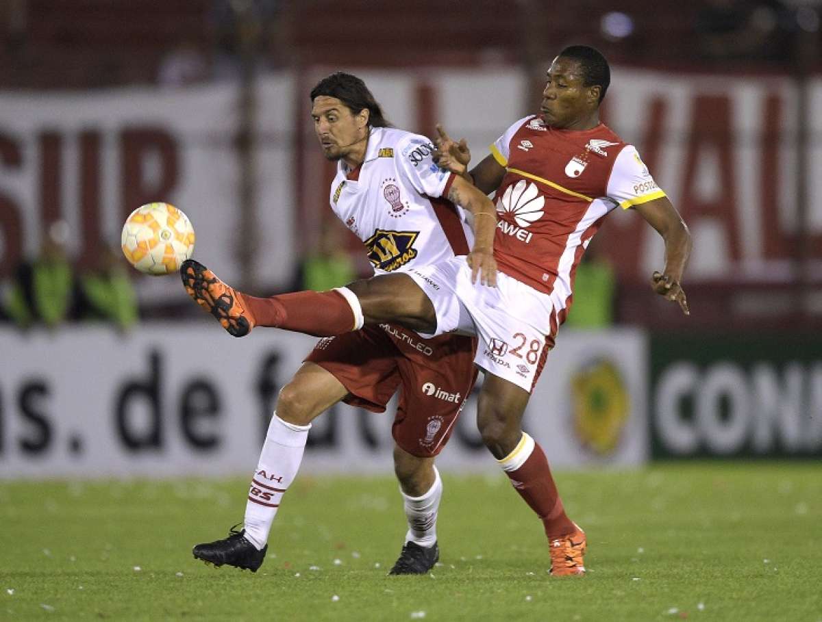 Daniel Angulo (d) disputa el esf&eacute;rico con el argentino Federico Vismara, de Hurac&aacute;n. Foto: AFP