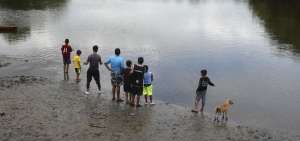 Un grupo de ni&ntilde;os y j&oacute;venes prueba suerte con la pesca utilizando cordeles de nylon, anzuelos y carnadas al pie del balneario de Puerto Hondo.