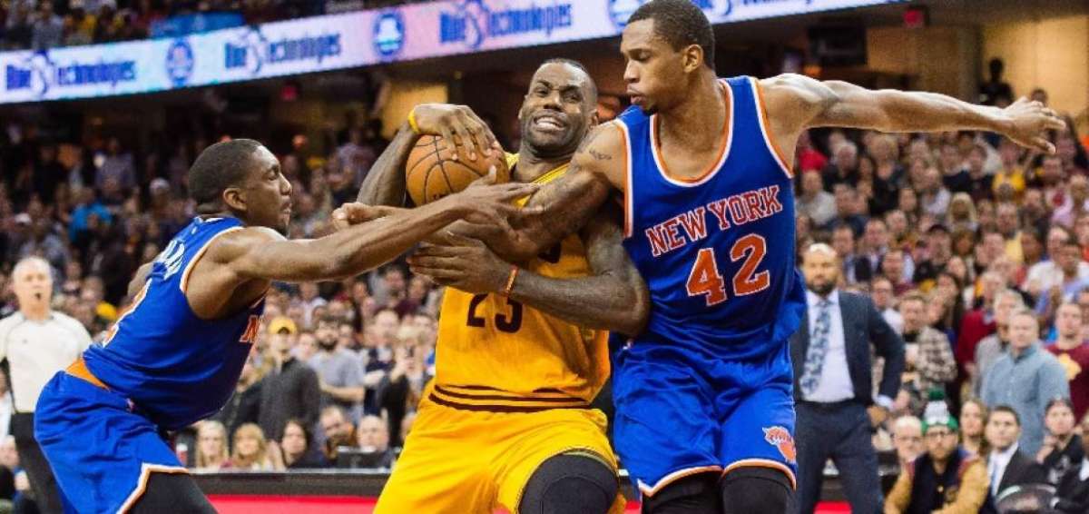 LeBron James (i) es marcado por dos jugadores que le cometieron una falta durante el partido de los Cavaliers ante Knicks.
