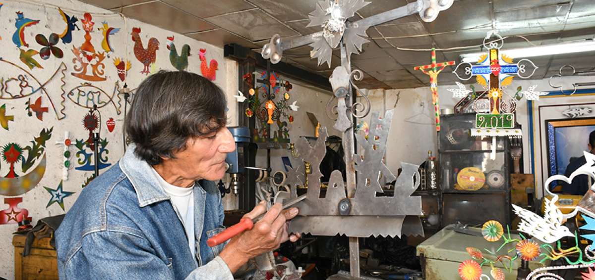 Amadeo V&aacute;squez elabora cruces de hierro en su taller ubicado en la Bajada del Padr&oacute;n, donde exhibe sus trabajos. Aprendi&oacute; el oficio a los 12 a&ntilde;os y comenz&oacute; con la fabricaci&oacute;n de barretas, picos, rejas y arados para los bueyes.