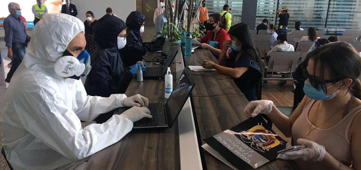As&iacute;, protegidos con trajes de bioseguridad reciben a los pasajeros en el aeropuerto de Guayaquil.