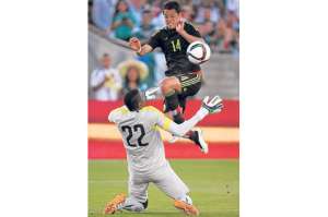 El arquero ecuatoriano Alexander Dom&iacute;nguez (22) bloquea un ataque del delantero mexicano Javier Hern&aacute;ndez. Foto: AFP