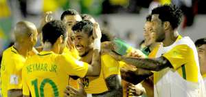 Neymar celebra a Paulinho, autor de un hat-trick, en la goleada frente a Uruguay en el estadio Centenario.  