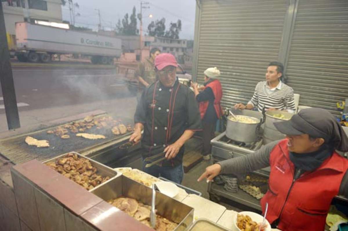 Clara Sol&iacute;s, junto a sus ayudantes, asa carnes en la puerta de su local. En ese lugar se puede degustar morcillas, chinchulines, pollo asado y caldos de 31. Foto: Roberto Ch&aacute;vez.