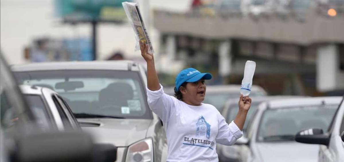 Mercedes grita de manera repetida: &ldquo;Agua, agua helada... EL TEL&Eacute;GRAFO... Inf&oacute;rmate&rdquo;. Aprovecha la luz roja para caminar entre los carros y vender.