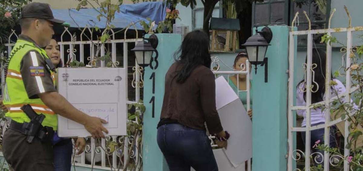 Polic&iacute;as y miembros de la Junta Receptora del Voto M&oacute;vil ingresan al domicilio de uno de los beneficiados durante el simulacro en Santa Elena.