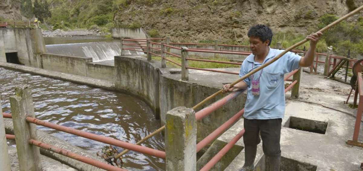 Un trabajador limpia uno de los canales que lleva el agua a la represa de Chiquihurcu, la cual provee agua a las ciudades de Ambato y Pelileo.