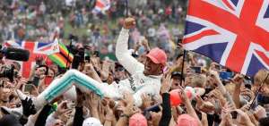 Un grupo de aficionados levanta en brazos a Lewis Hamilton despu&eacute;s de ganar el circuito de Silverstone.  Cortes&iacute;a F&oacute;rmula Uno 