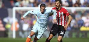 Hazard (celeste) disputa el bal&oacute;n durante un partido de la Premier League.