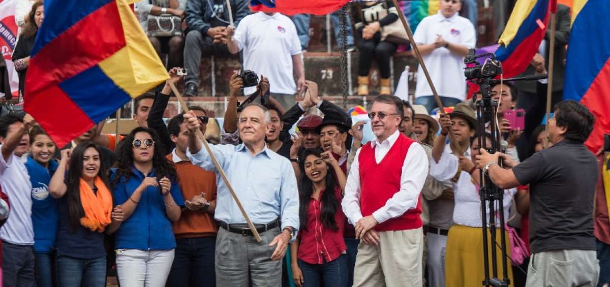 Paco Moncayo agita una bandera de Ecuador durante la convenci&oacute;n. A su lado est&aacute; Enrique Ayala Mora.