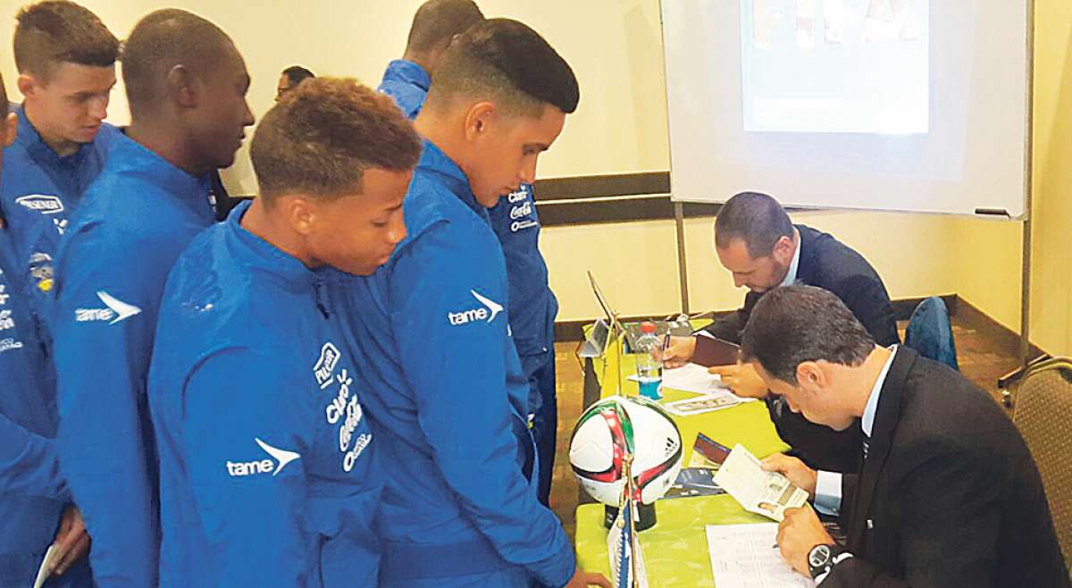 Dos delegados de la FIFA revisan los pasaportes de los jugadores de la Selecci&oacute;n Ecuatoriana Sub-17 y contrastan la informaci&oacute;n con las hojas de inscripci&oacute;n. Foto: cortes&iacute;a