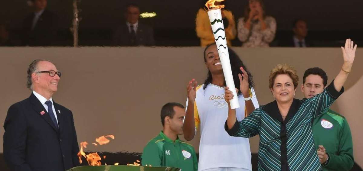 La presidenta de Brasil, Dilma Rousseff (d), saluda con la antorcha ol&iacute;mpica en Brasilia.