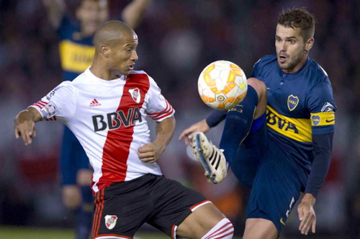 Carlos S&aacute;nchez (i) disputa la pelota con el volante de Boca Juniors, Fernando Gago (d), durante el partido por los octavos de final de la Copa Libertadores. Foto: AFP