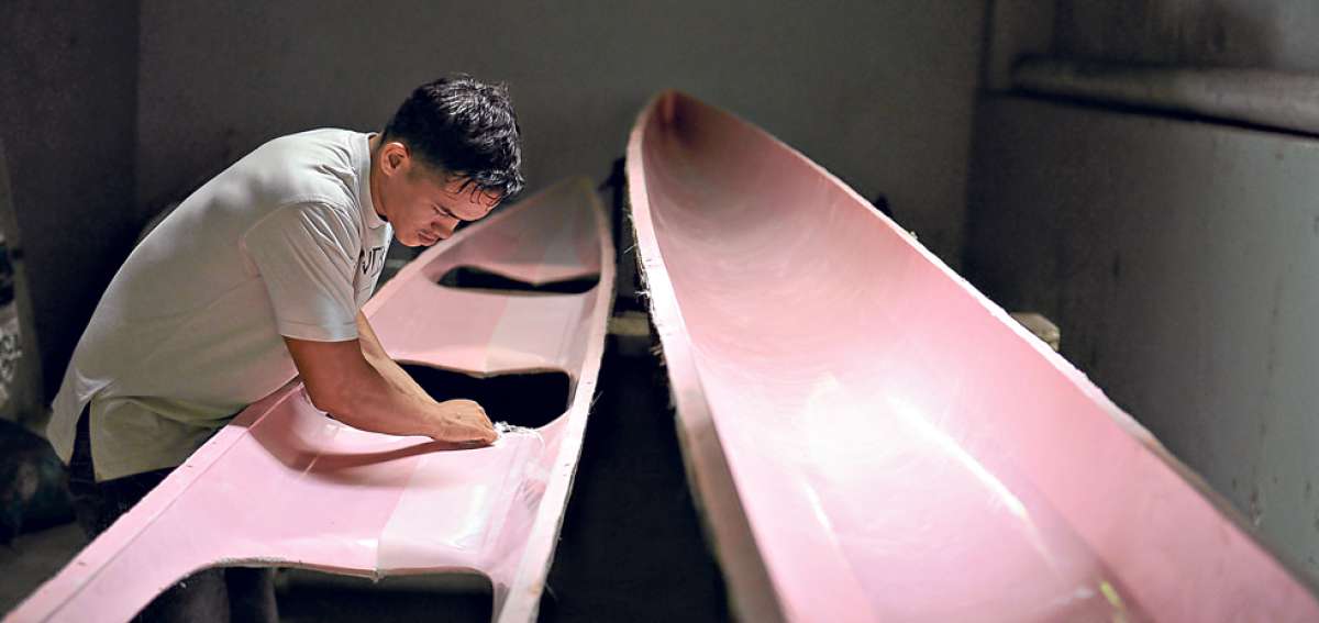 Jorge Dicado encera y lamina los botes. Este deportista de 20 a&ntilde;os estudia para ser chef y analiza la posibilidad de construir tablas de surf por la temporada. Foto: Jos&eacute; Mor&aacute;n / El Tel&eacute;grafo.