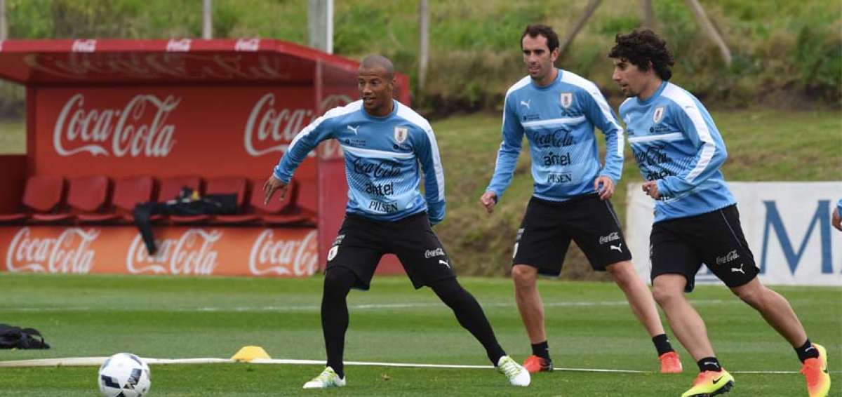 El volante Carlos S&aacute;nchez (izq.) domina el bal&oacute;n ante la marca de dos compa&ntilde;eros, ayer en Montevideo.  