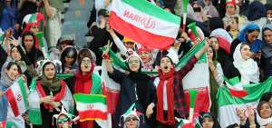 Aficionadas iran&iacute;es animan con banderas, gorros con los colores nacionales y trompetas a su selecci&oacute;n en el Azadi Stadium de Teher&aacute;n, en el encuentro ante Camboya.