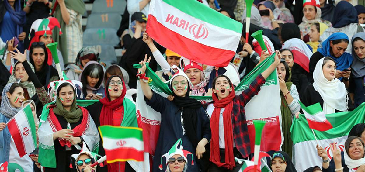 Aficionadas iran&iacute;es animan con banderas, gorros con los colores nacionales y trompetas a su selecci&oacute;n en el Azadi Stadium de Teher&aacute;n, en el encuentro ante Camboya.