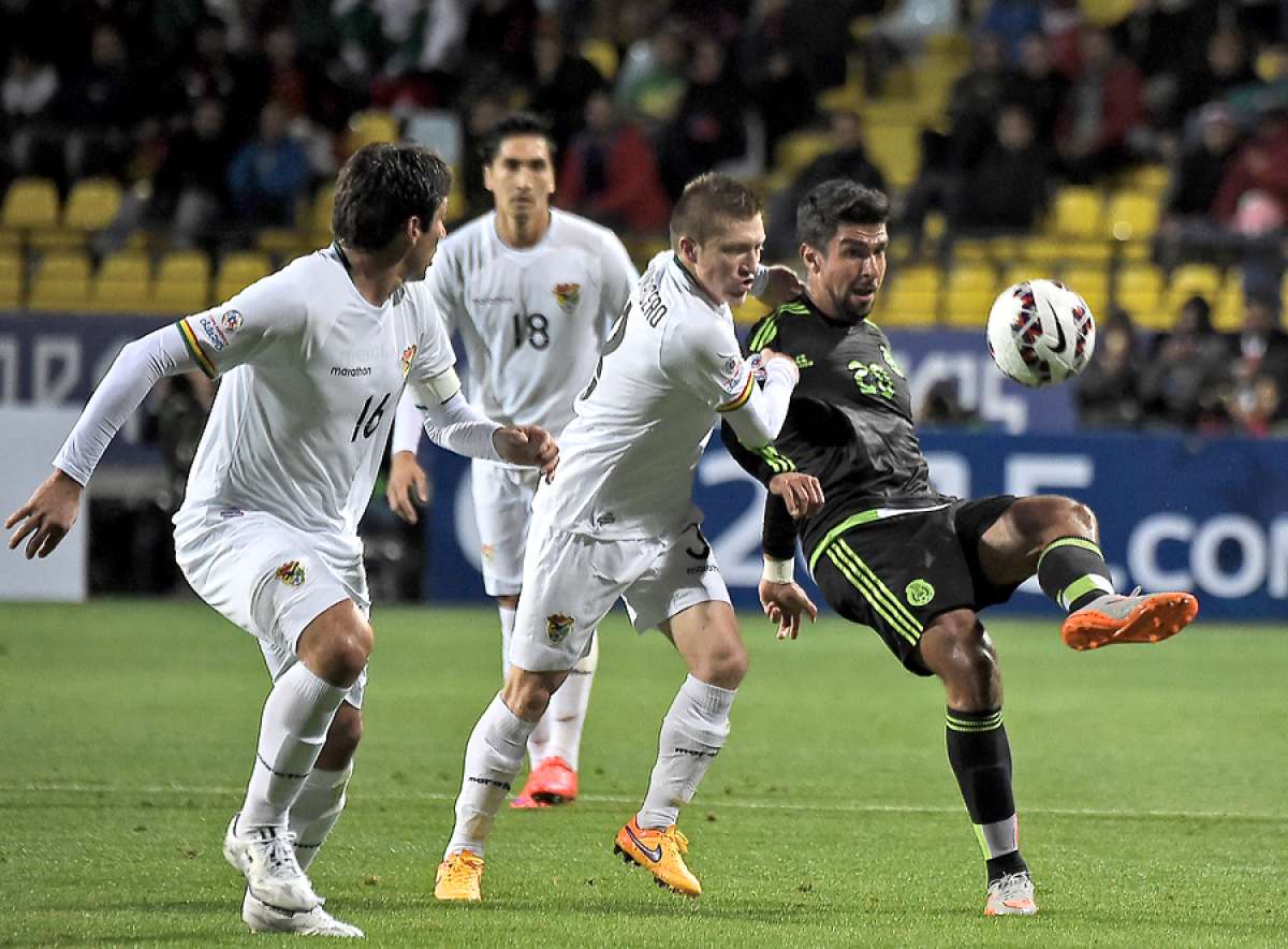 El delantero mexicano Eduardo Herrera (d) intenta eludir la marca de dos defensas bolivianos en el partido de debut de ambas selecciones en Vi&ntilde;a del Mar. Foto: AFP