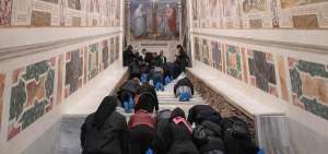 Varias personas recorren de rodillas la Escalera Santa durante su apertura extraordinaria en la Bas&iacute;lica de San Juan de Letr&aacute;n, Roma (Italia).
