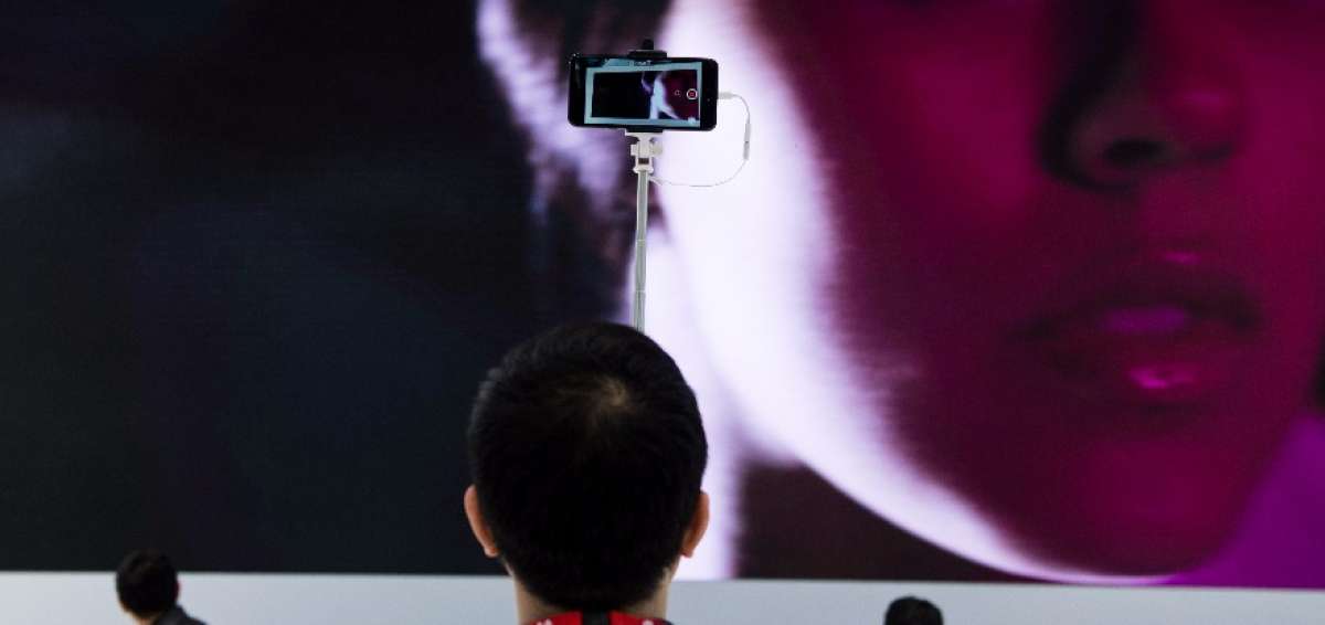 Un visitante de la Convenci&oacute;n en Barcelona utiliza su celular para fotografiarse en el evento. 