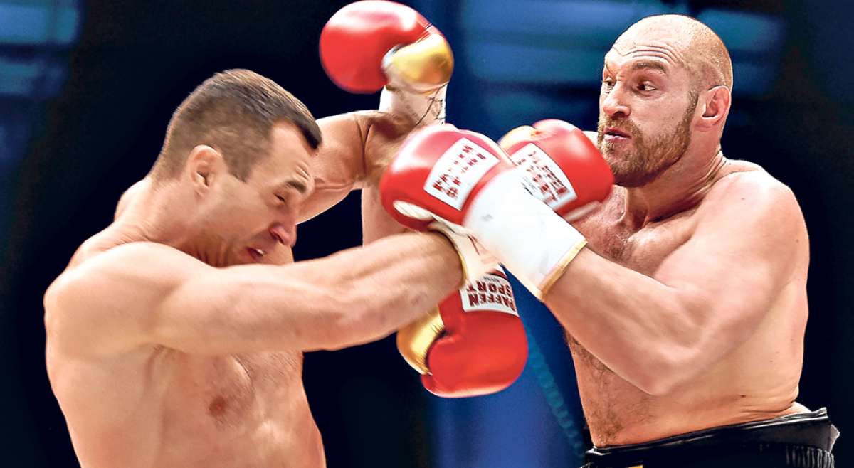 El ucraniano Wladimir Klitschko se protege de los golpes que le propina Tyson Fury, durante el combate del s&aacute;bado pasado en Dusseldorf, Alemania. Foto: AFP