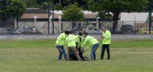 Agentes de la Polic&iacute;a Nacional recogen el cuerpo de uno de los desafortunados polizones que murieron al caer de un avi&oacute;n en decolaje.