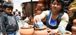 &rarr;Narcisa Guam&aacute;n coloca caramelos y confites dentro de una olla encantada lista para la venta.