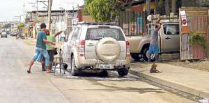 En la avenida Isidro Ayora existen 9 lugares donde a&uacute;n permanece el servicio informal de lavado de autos. Foto: Pilar Vera / El Tel&eacute;grafo