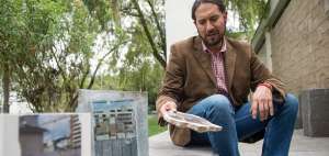 Eduardo Valenzuela sostiene un pedazo de pared con una fotograf&iacute;a impresa de Quito.