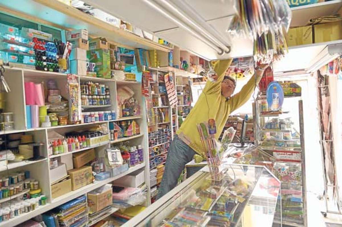 Patricio Rodr&iacute;guez, due&ntilde;o de librer&iacute;a Ilusi&oacute;n, adec&uacute;a y acomoda los insumos escolares que van llegando, en estos d&iacute;as, en las estanter&iacute;as de su local. Foto: Roberto Ch&aacute;vez / El Tel&eacute;grafo