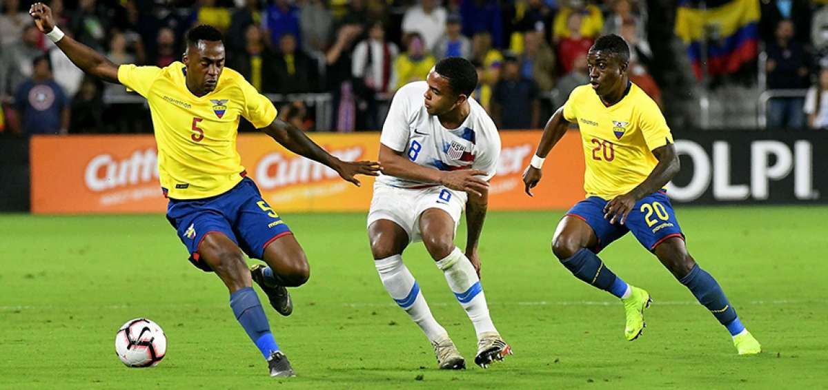 Los ecuatorianos Renato Ibarra (5) y Sebasti&aacute;n M&eacute;ndez (20) disputan el bal&oacute;n contra un jugador de los EE.UU.
