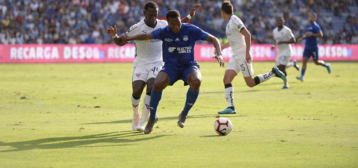 El delantero Daniel Angulo, de Emelec, protege la pelota ante la marca de Luis Caicedo, durante un partido por la LigaPro en el Capwell.