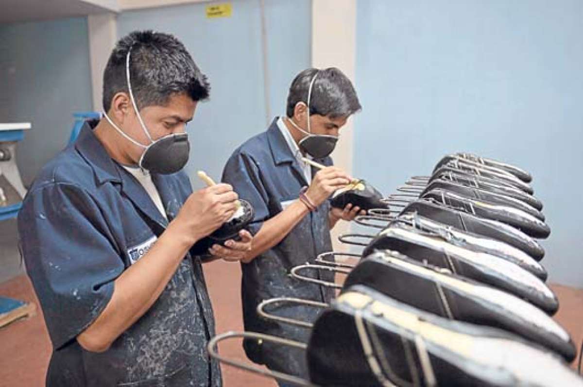 Las empresas predominantes en Tungurahua abarcan las &aacute;reas de publicidad, textiles y calzado. En la gr&aacute;fica, 2 j&oacute;venes trabajan en una zapater&iacute;a. Foto: Roberto Ch&aacute;vez.