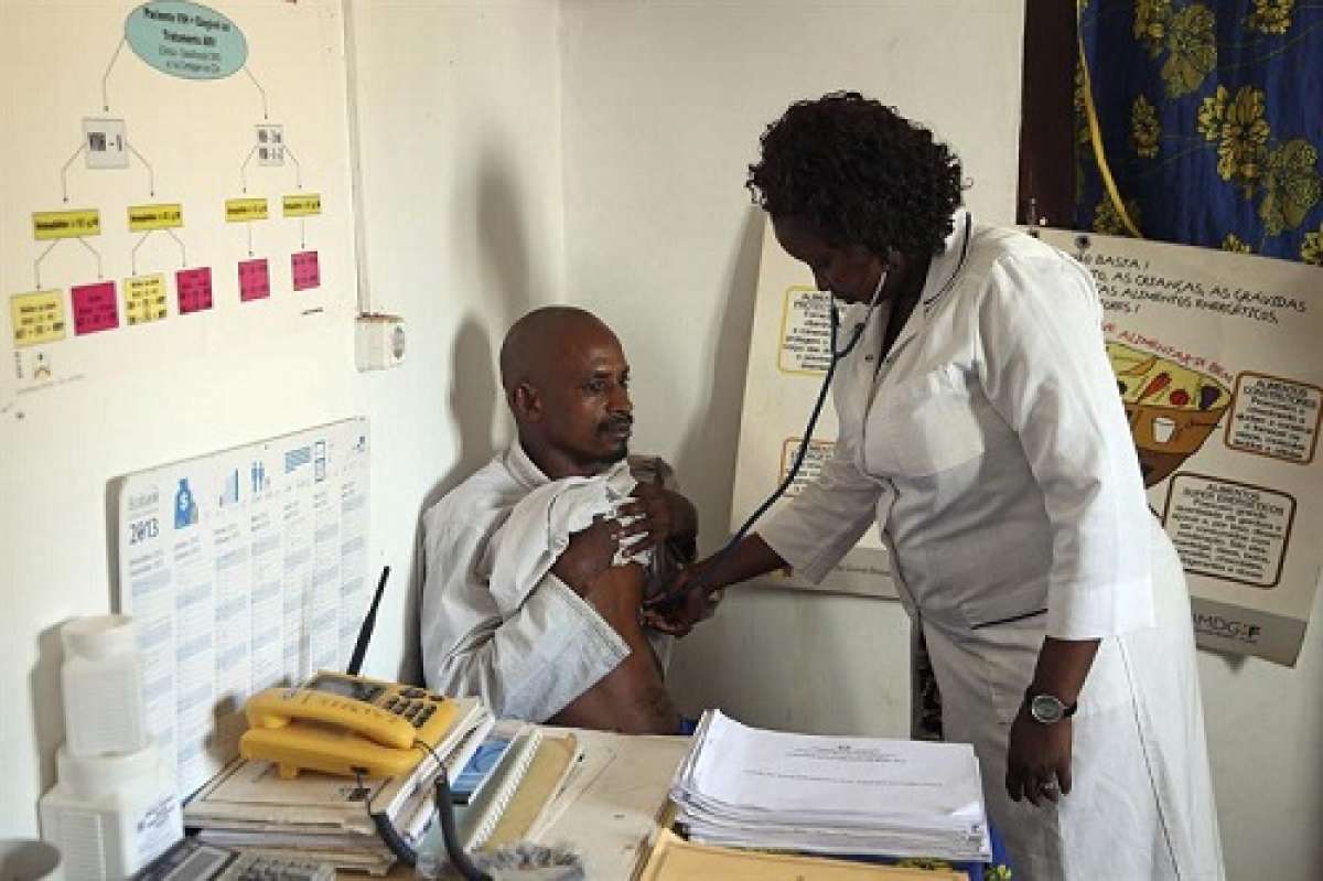 La enfermera guineana Egidia Almeida (der) osculta a un ciudadano procedente de Guinea Conakry en un centro m&eacute;dico a la entrada fronteriza de Buruntuma (Guinea-Bissau). Foto: EFE