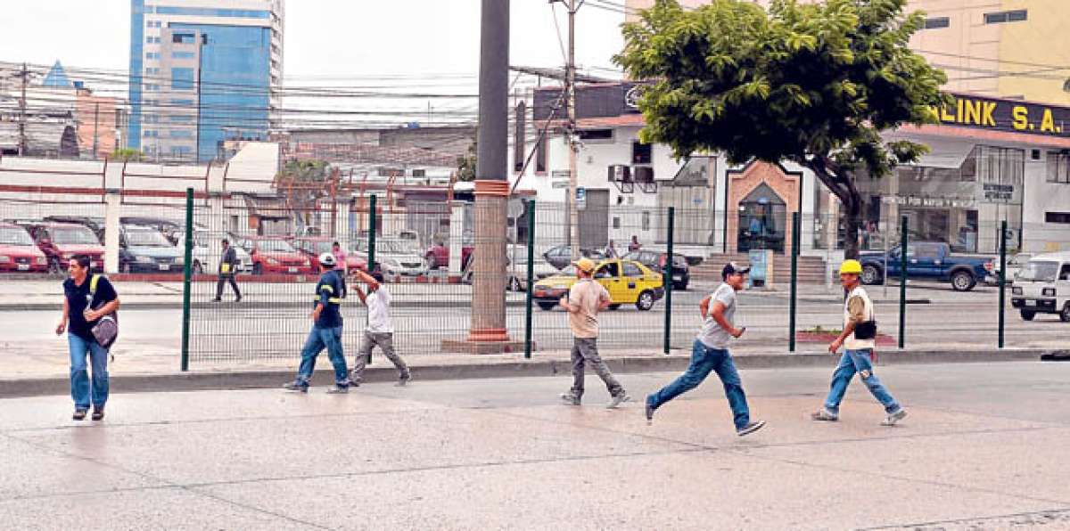 Transe&uacute;ntes cruzan corriendo la Juan Tanca Marengo, al norte. En la zona el Cabildo puso barreras met&aacute;licas. Foto: Alfredo Piedrah&iacute;ta / El Tel&eacute;grafo
