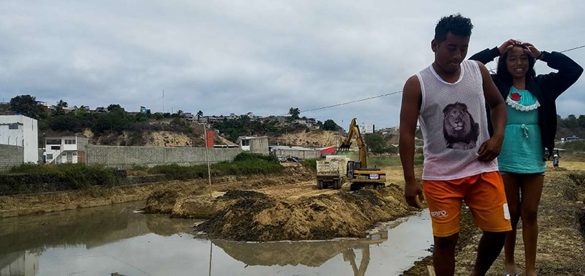 Los ciudadanos que viven cerca de la comunidad R&iacute;o Manta caminan sobre muros de gaviones del r&iacute;o Manta. 