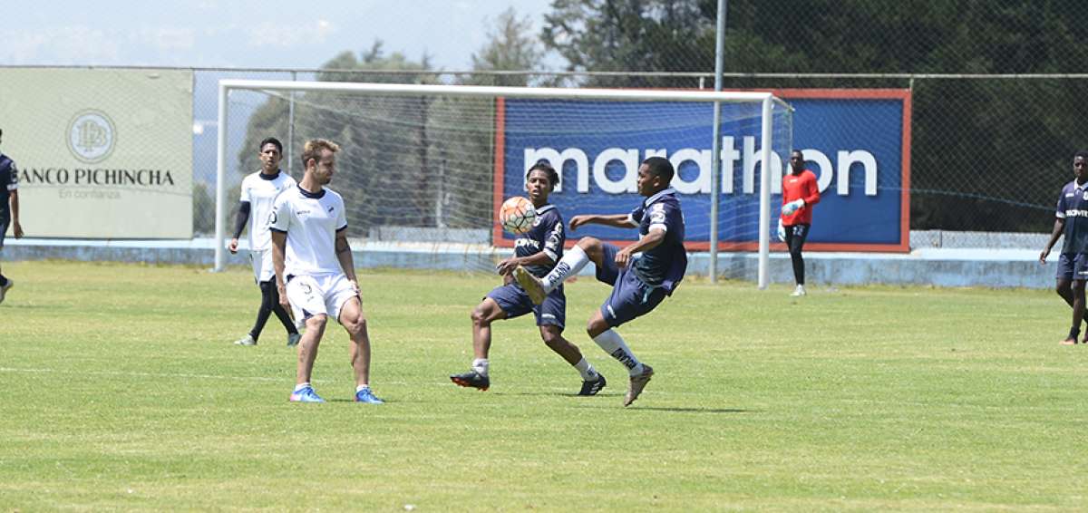 El volante argentino Gast&oacute;n Gil Romero (izq.) disputa un bal&oacute;n con elementos del equipo de la reserva de Cat&oacute;lica en una pr&aacute;ctica en la Armenia.