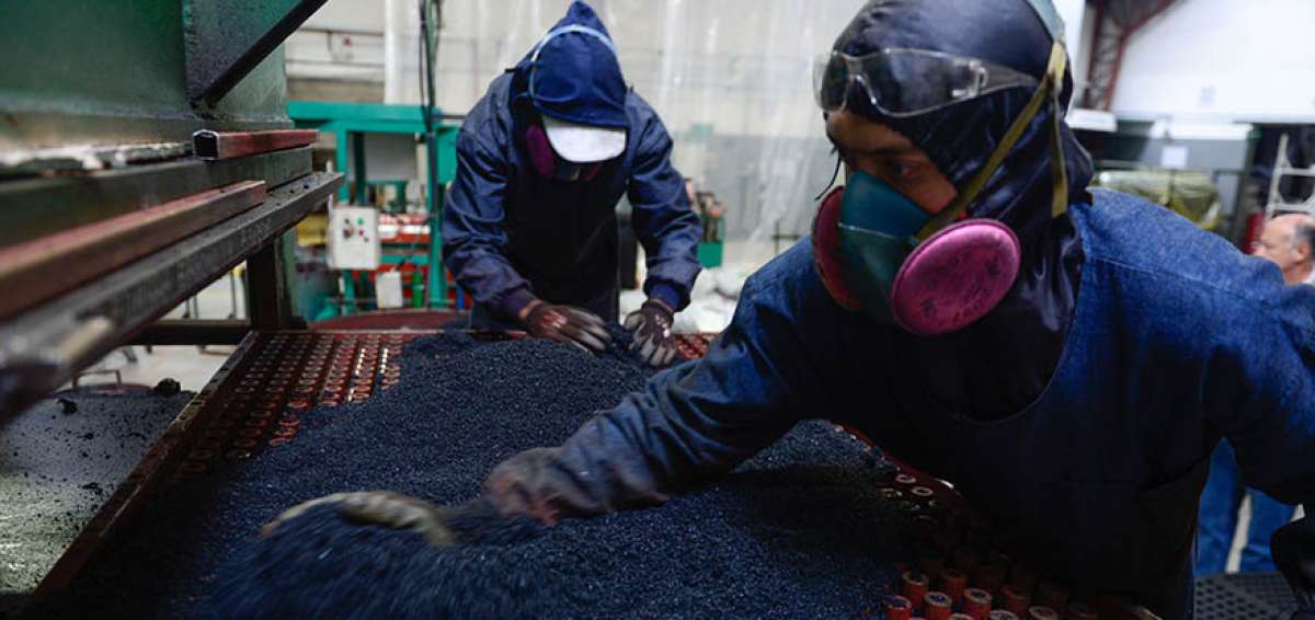 Obreros de la empresa Ecocaucho trabajan con el caucho granulado, producto de llantas usadas procesadas, con el cual se fabrican pisos para gimnasios.