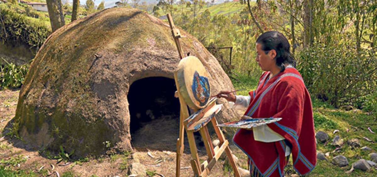 A la entrada de un inipi en Chibuleo, Sairy pinta la cara de un cham&aacute;n en trance. Sus obras se basan en paisajes andinos y escenas de la vida diaria en esta etnia, situada a 30 minutos de Ambato. Foto: Roberto Ch&aacute;vez / El Tel&eacute;grafo