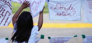 Una persona cuelga pa&ntilde;uelos blancos bordados con denuncias sobre las desapariciones forzadas y los nombres de sus seres queridos que se encuentran con paradero desconocido.