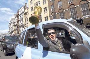 Un aficionado ingl&eacute;s muestra una r&eacute;plica del trofeo de la Copa del Mundo a su paso por una de las principales avenidas de Londres. Foto: EFE