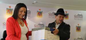 Daniela Culqui, directora del Ministerio del Ambiente en Cotopaxi, entrega los expedientes sobre el tema hidrocarbur&iacute;fero al prefecto Jorge Guam&aacute;n. 